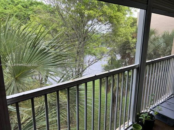 Panoramic view of the surrounding area seen from a balcony with lush trees visible.