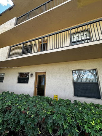 Front view of a multi-story building with balconies and a ground-level entrance.