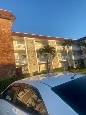 Front view of a multi-story building with balconies and decorative block design.
