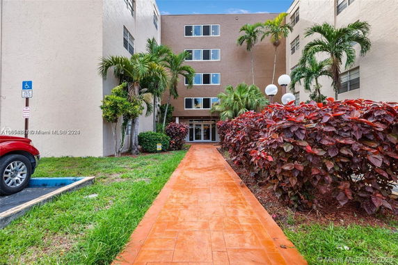 Front view of a multi-story building with a walkway leading to the entrance.