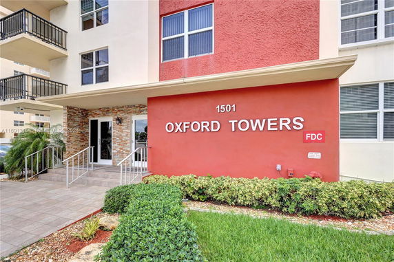 Front view of Oxford Towers entrance with a red facade.