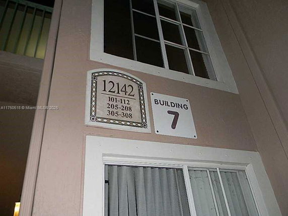 Front view of building with a number sign and room numbers listed.