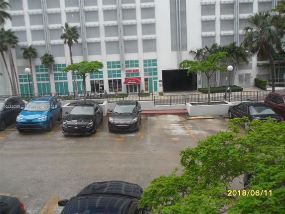 Front view of a multi-story building with a parking lot.