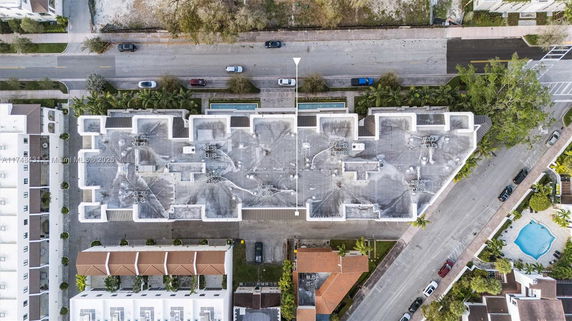 Aerial view of a building rooftop with visible air conditioning units and other equipment.
