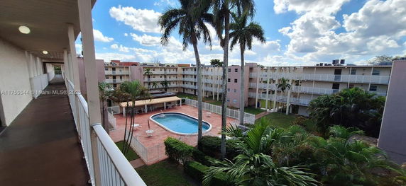 Outdoor view of an apartment complex with a swimming pool in the courtyard.