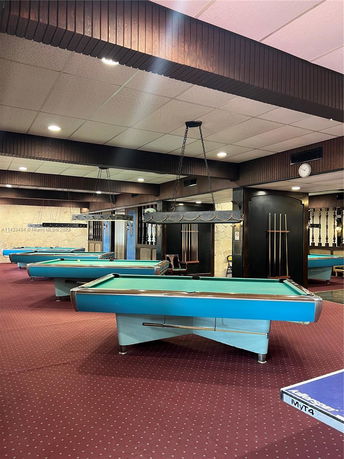 Indoor billiards room with multiple pool tables.