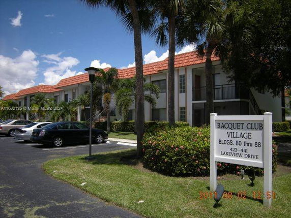 Front view of a two-story residential building with red-tiled roofs.