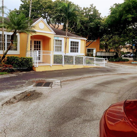 Front view of a single-story house with a yellow exterior and white railing.