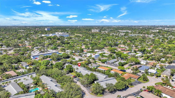 Panoramic view of a residential area with numerous houses, roads, and greenery.