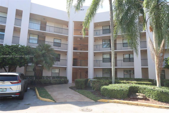 Front view of a multi-story apartment building with balconies.