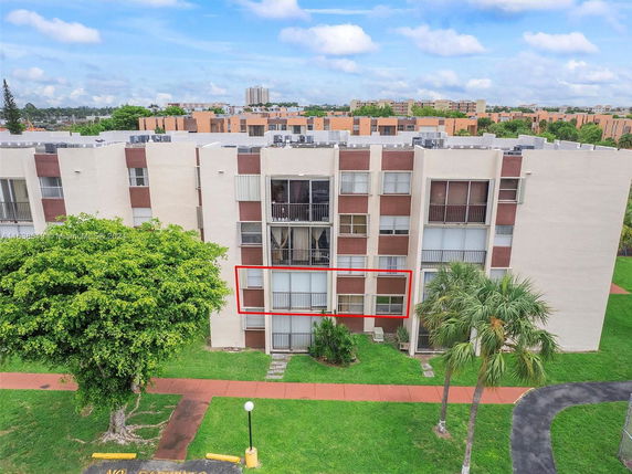 Front view of a multi-story residential building with large windows.
