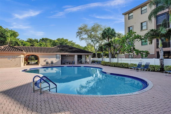 Outdoor swimming pool area with surrounding deck and chairs.