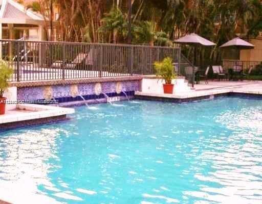 Outdoor swimming pool with a railing and potted plants.