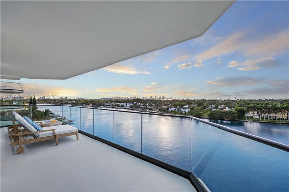 View from a balcony overlooking a body of water and distant cityscape.