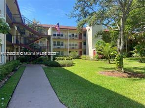 View from outside showing a multi-story residential building with balconies and American flag.