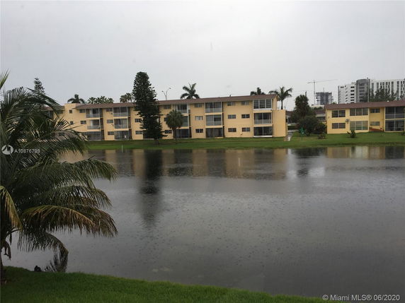 View of multiple low-rise apartment buildings across a body of water.