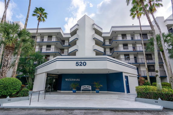 Front view of a multi-story building with balconies and a blue entrance.