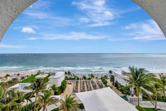 Ocean view with beach and outdoor lounge area, seen from a higher elevation.