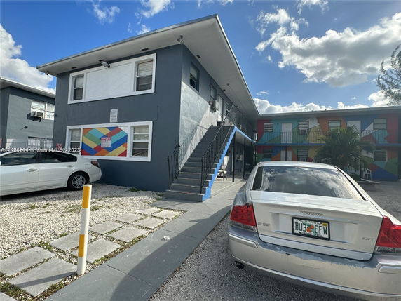 Front view of a two-story apartment building with colorful mural.