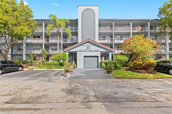 Front view of a multi-story building with balconies and a centered entrance.
