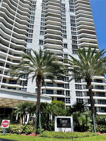 Front view of a high-rise residential building named Tower 100 with multiple balconies.