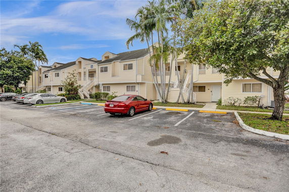 Outdoor parking area in front of a multi-story residential building.