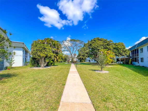View of surrounding area with grass and trees between residential buildings.