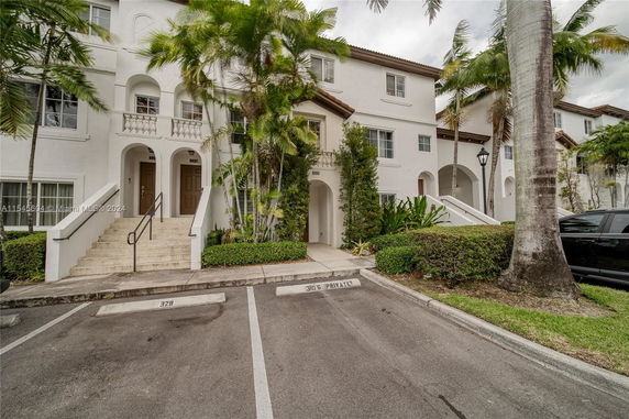 Front view of a multi-story residential building with staircases leading to entrance doors.