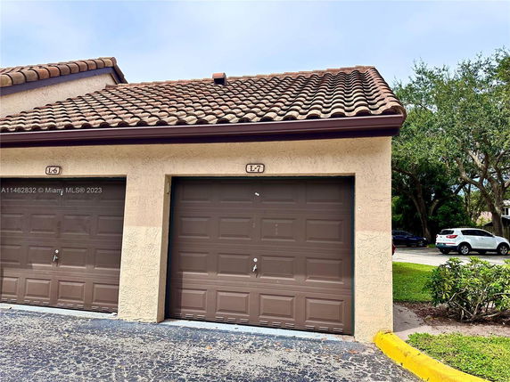 Front view of a building with two closed garage doors and a tiled roof.