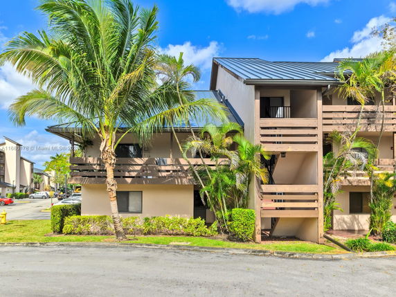 Front view of a two-story residential building with a sloped roof and balconies.