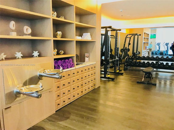 Interior view of a gym with exercise equipment and storage shelves.