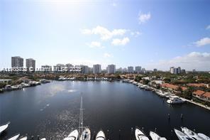 Panoramic view overlooking a body of water with boats and city skyline in the distance.