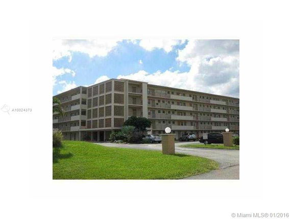 Front view of a multi-story apartment building with balconies.