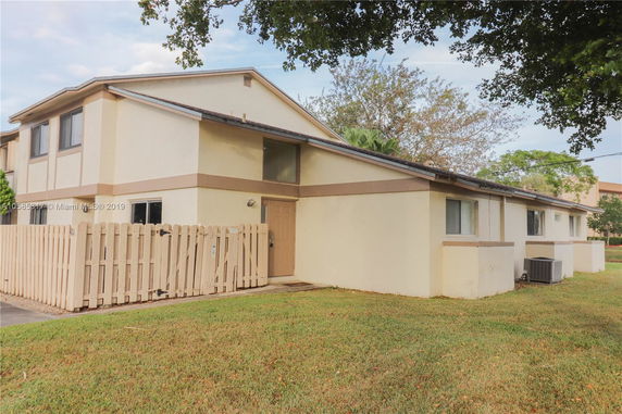 Front view of a two-story house with a wooden fence.