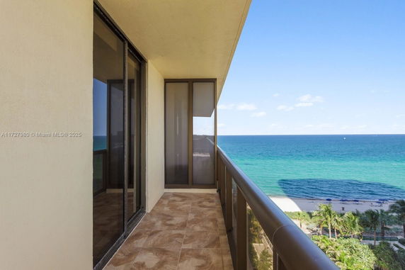 Balcony with ocean view and glass railings.