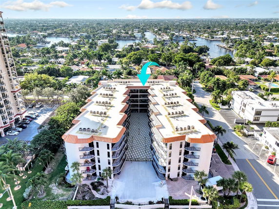 Elevated view of a multi-story residential building with multiple balconies and a surrounding urban area.