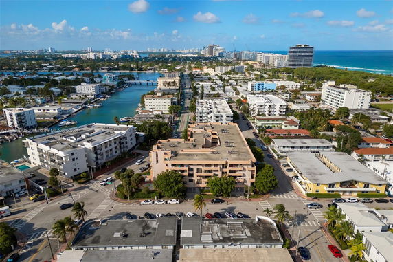 Aerial view of a coastal city with residential buildings, roads, and water bodies.
