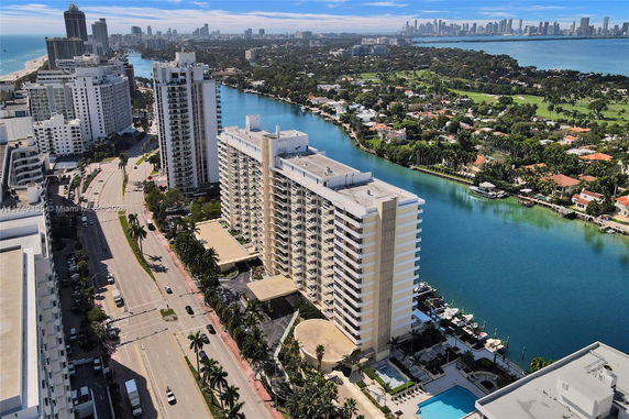 Panoramic view of a coastal city with high-rise buildings and a waterway.