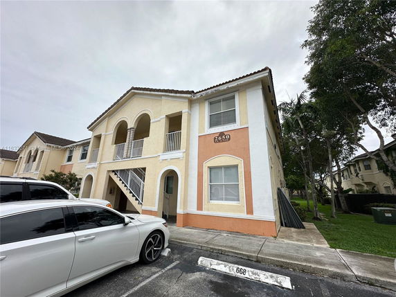 Front view of a two-story building with arches and balconies.