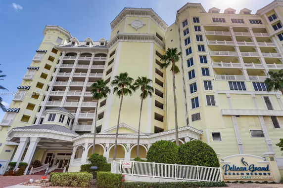 Front view of a multi-story resort building with yellow exterior and balconies.