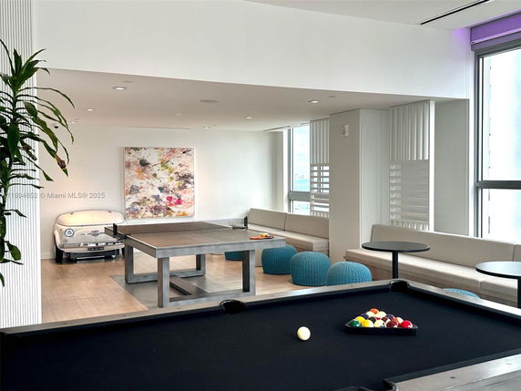 Indoor recreation area with pool and ping pong tables.