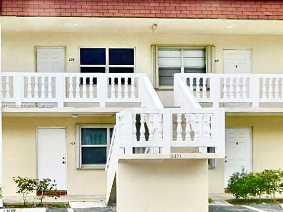 Front view of a two-story building with stairs leading to the upper level.
