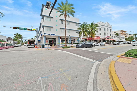 Street view of a multi-story building with shops on the ground floor.