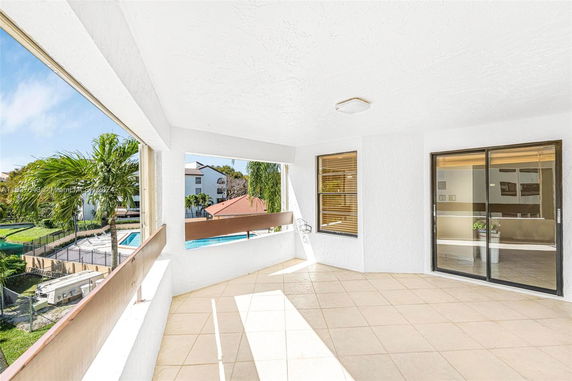 View from a balcony showing neighboring buildings and a swimming pool.