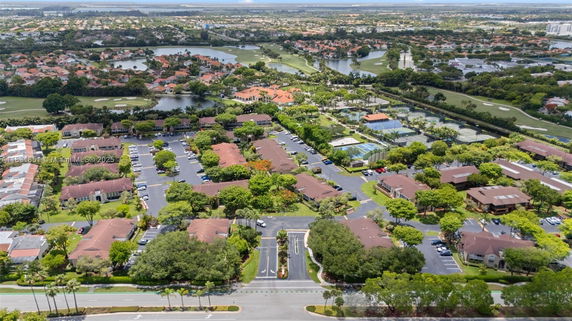 Aerial view of a residential area with various buildings, roads, and greenery.