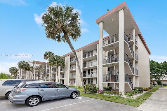 Front view of a multi-story building with balconies and external staircases.