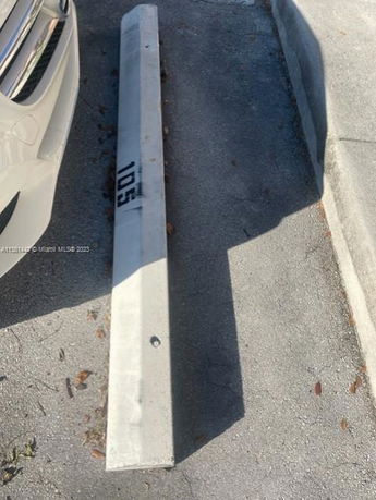 Outdoor parking area with a concrete parking stop numbered 105