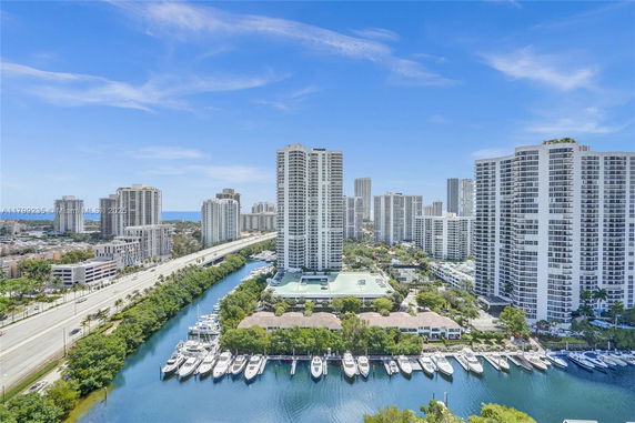 Panoramic view of high-rise buildings near a waterway with boats docked.