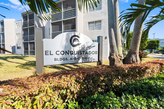 Front view of a multi-story apartment building complex with a sign reading 'El Conquistador'.