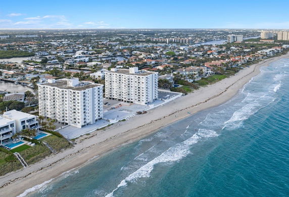 Aerial view of beachfront apartment buildings adjacent to a coastline.